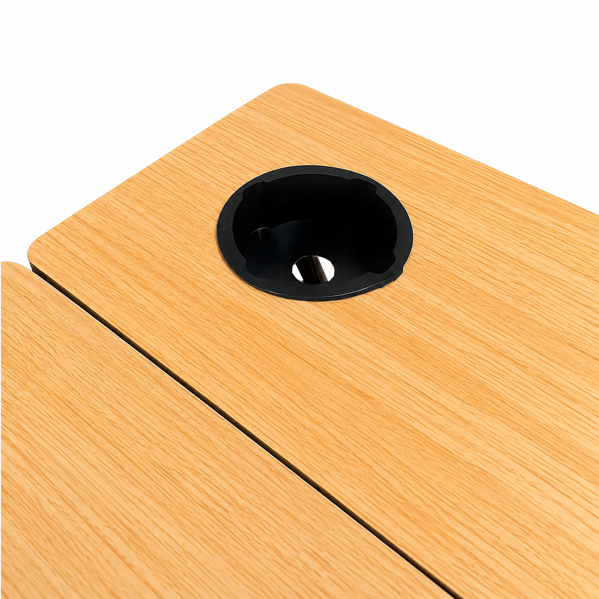 Mesa de madera con un portavasos negro y redondo integrado en la superficie sobre fondo blanco.