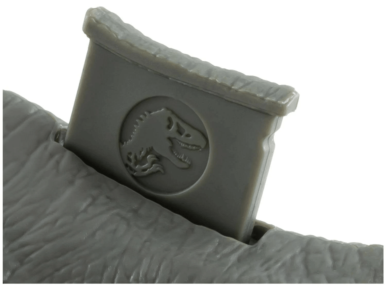 Un juguete de plástico gris que muestra el logotipo de Jurassic Park.