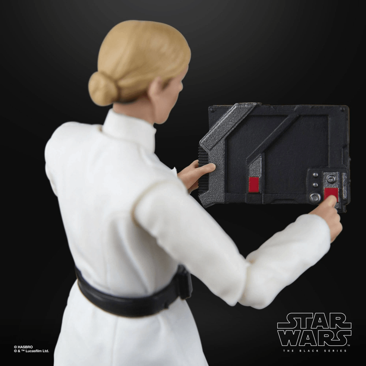 Figura con túnica blanca desde atrás sosteniendo un dispositivo negro.
