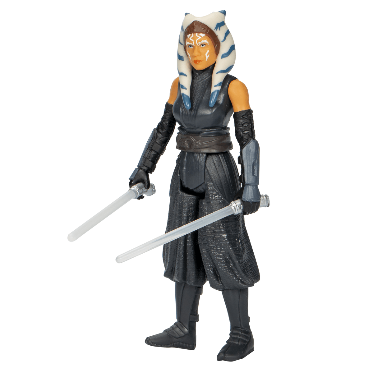 Action figure di Ahsoka Tano in abiti scuri con due spade laser su sfondo bianco.