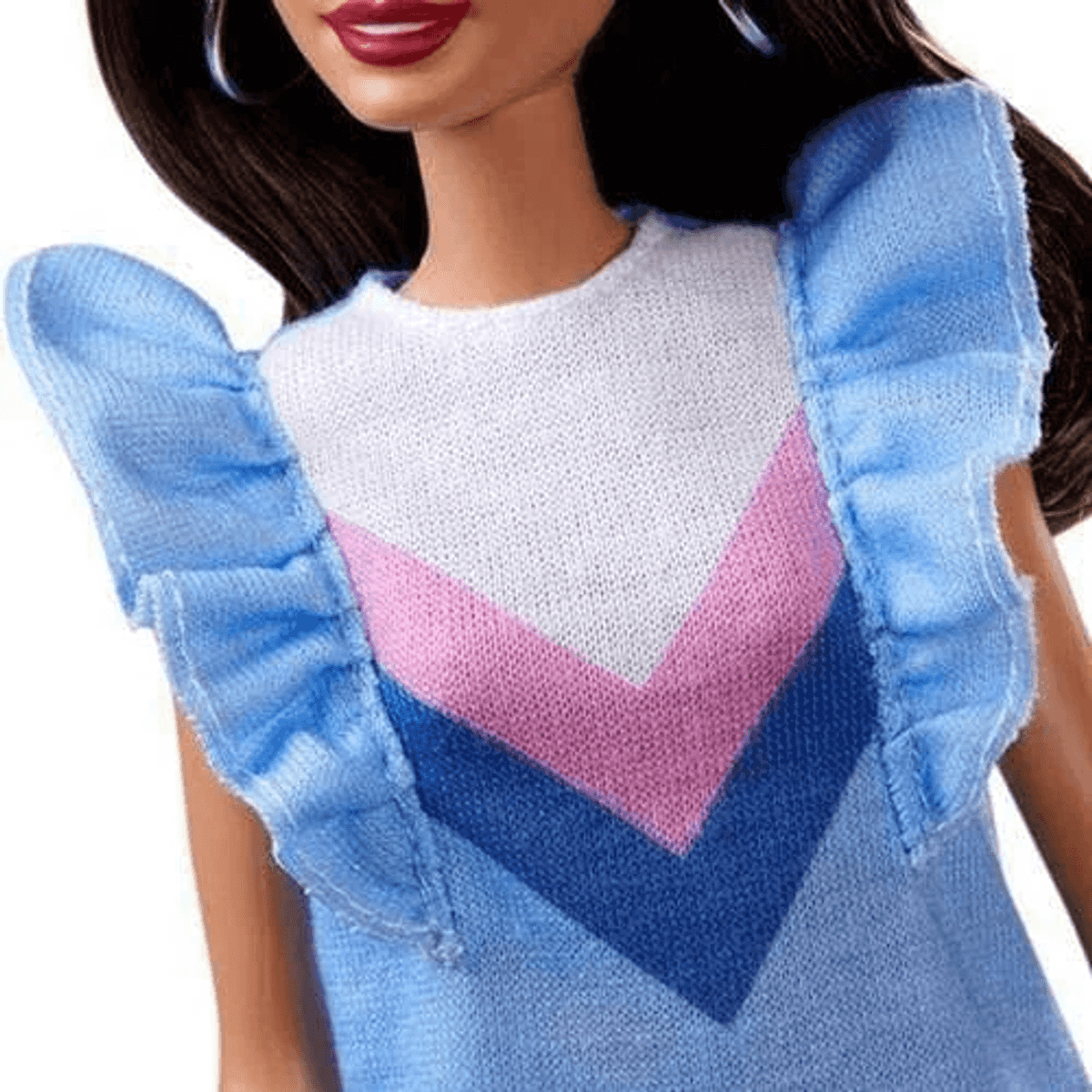 Nahaufnahme einer Puppe in einem blauen Kleid mit Rüschenärmeln und weißem, rosa und dunkelblauem Chevron-Muster.