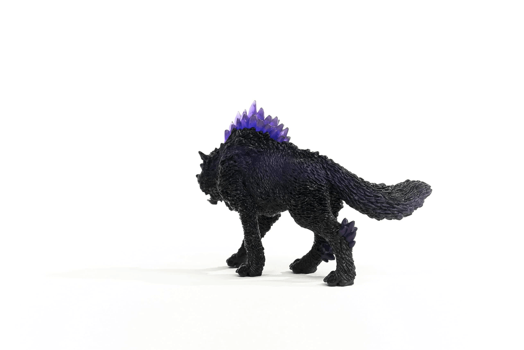 Eine schwarze Wolfsfigur mit violetten Kristallen auf dem Rücken und einem weißen Hintergrund.