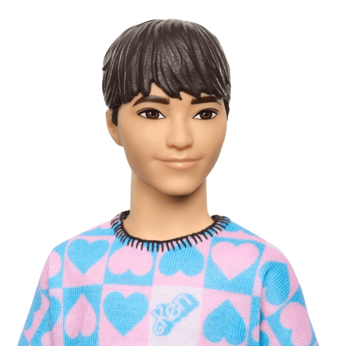 Nahaufnahme einer männlichen Modepuppe mit kurzem dunklem Haar und einem rosa-blauen Pullover mit Herzmustern.