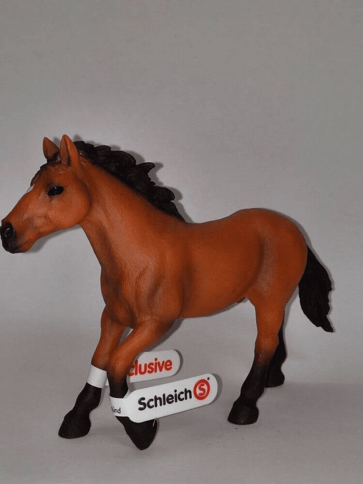 Una statuetta di cavallo Schleich marrone con criniera e coda nere su sfondo bianco.