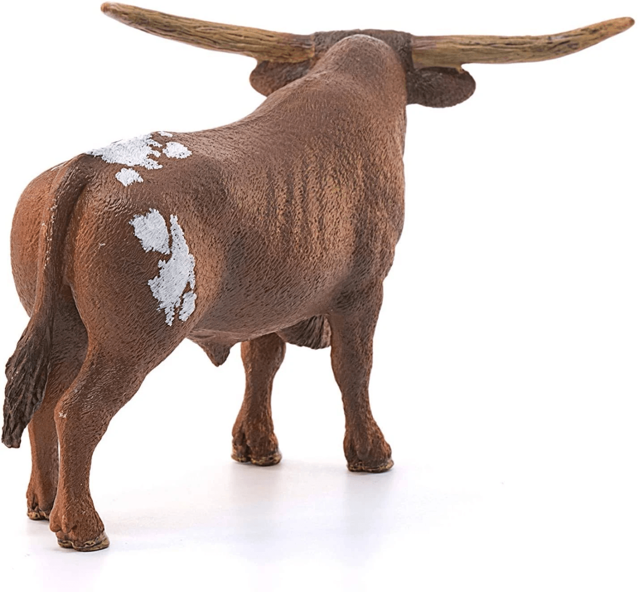 Una figura de toro longhorn marrón vista desde atrás, con manchas blancas y cuernos largos sobre fondo blanco.