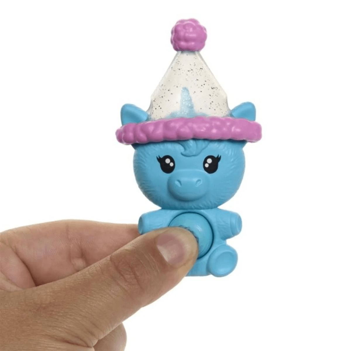 Eine Hand hält eine kleine blaue Figur mit großer Mütze und Glitzer gegen einen weißen Hintergrund.
