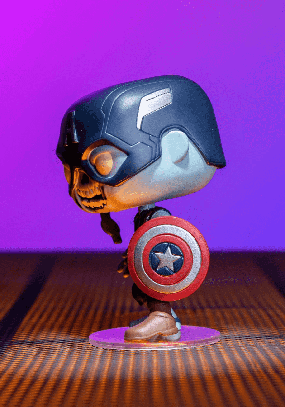 Figura Funko Pop zombie di Capitan America con scudo, in piedi su una piattaforma rotonda su sfondo viola.