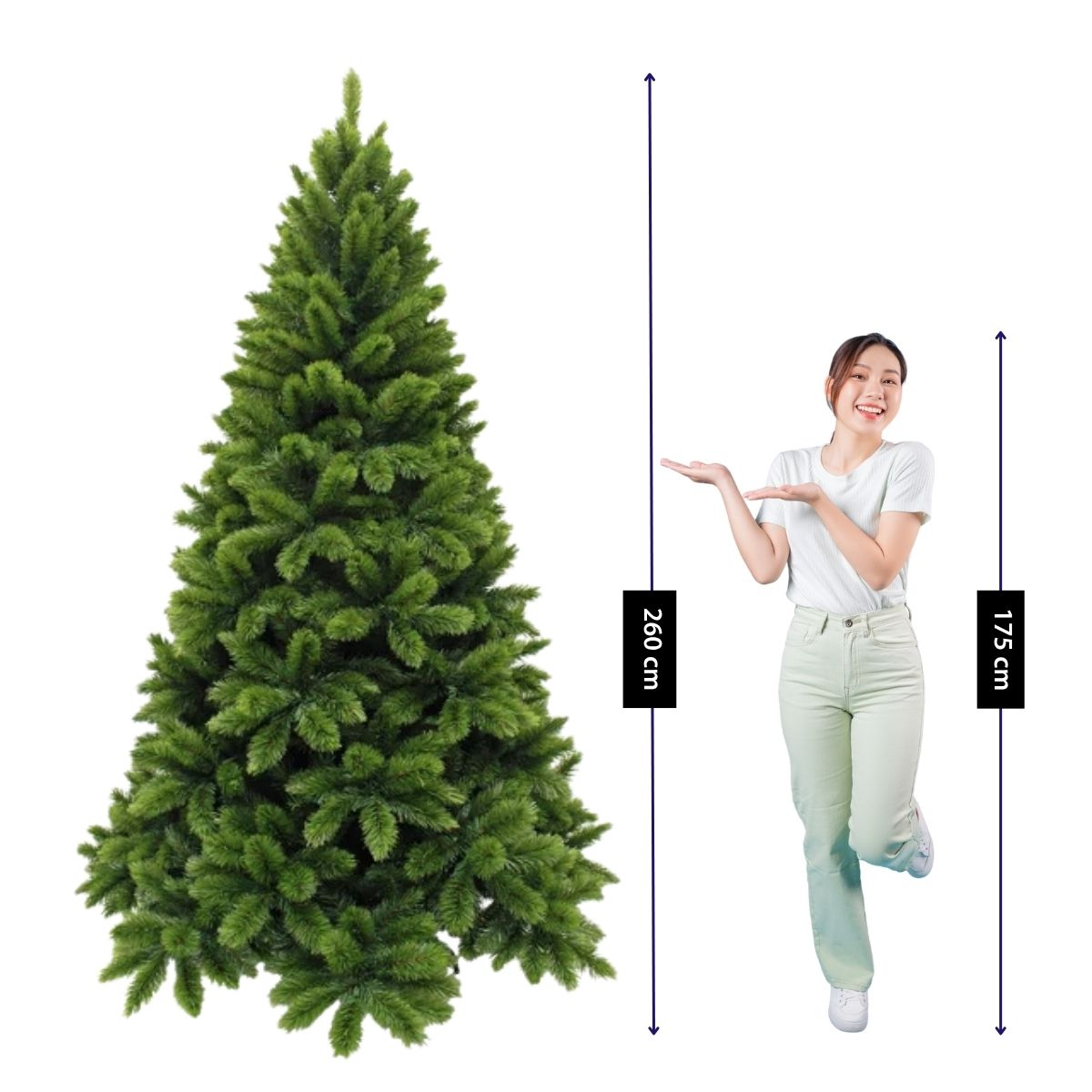 Une femme souriante pose à côté d'un sapin de Noël artificiel de 260 cm, comparé à sa taille de 175 cm.