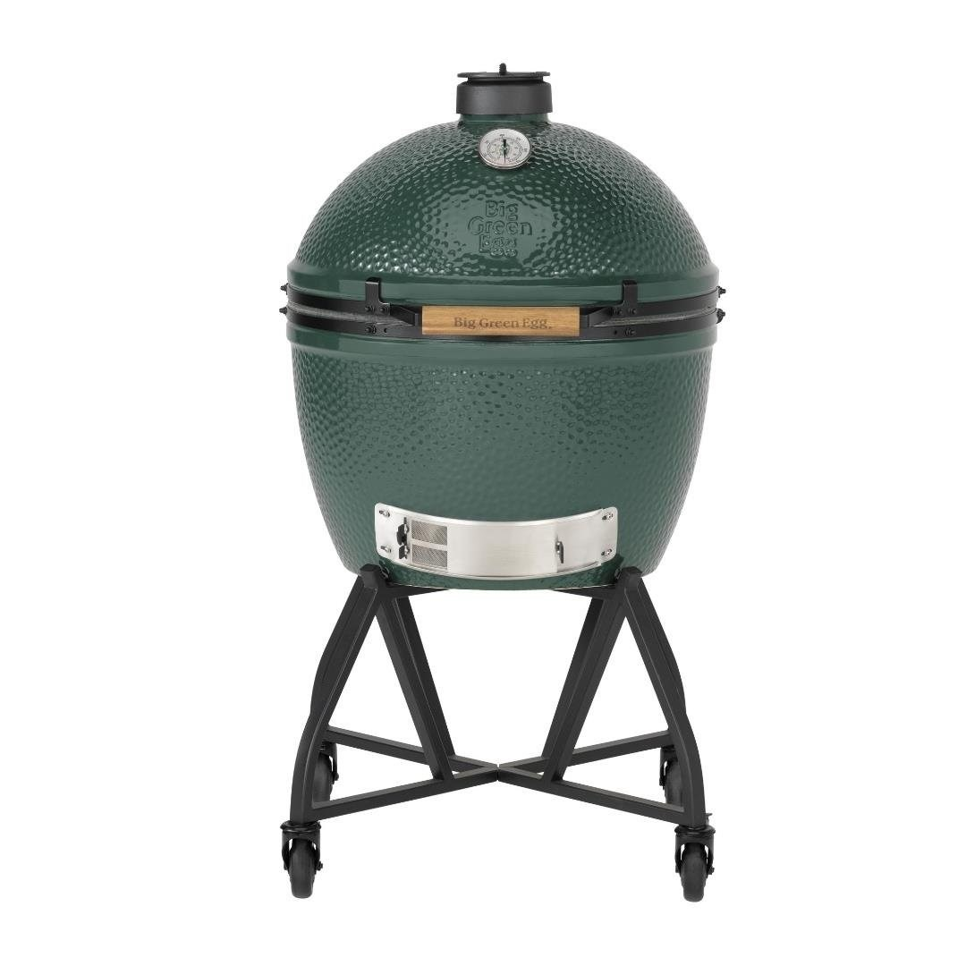 Beyaz arka planda siyah tekerlekli metal stant üzerinde büyük yeşil seramik kamado tarzı mangal.