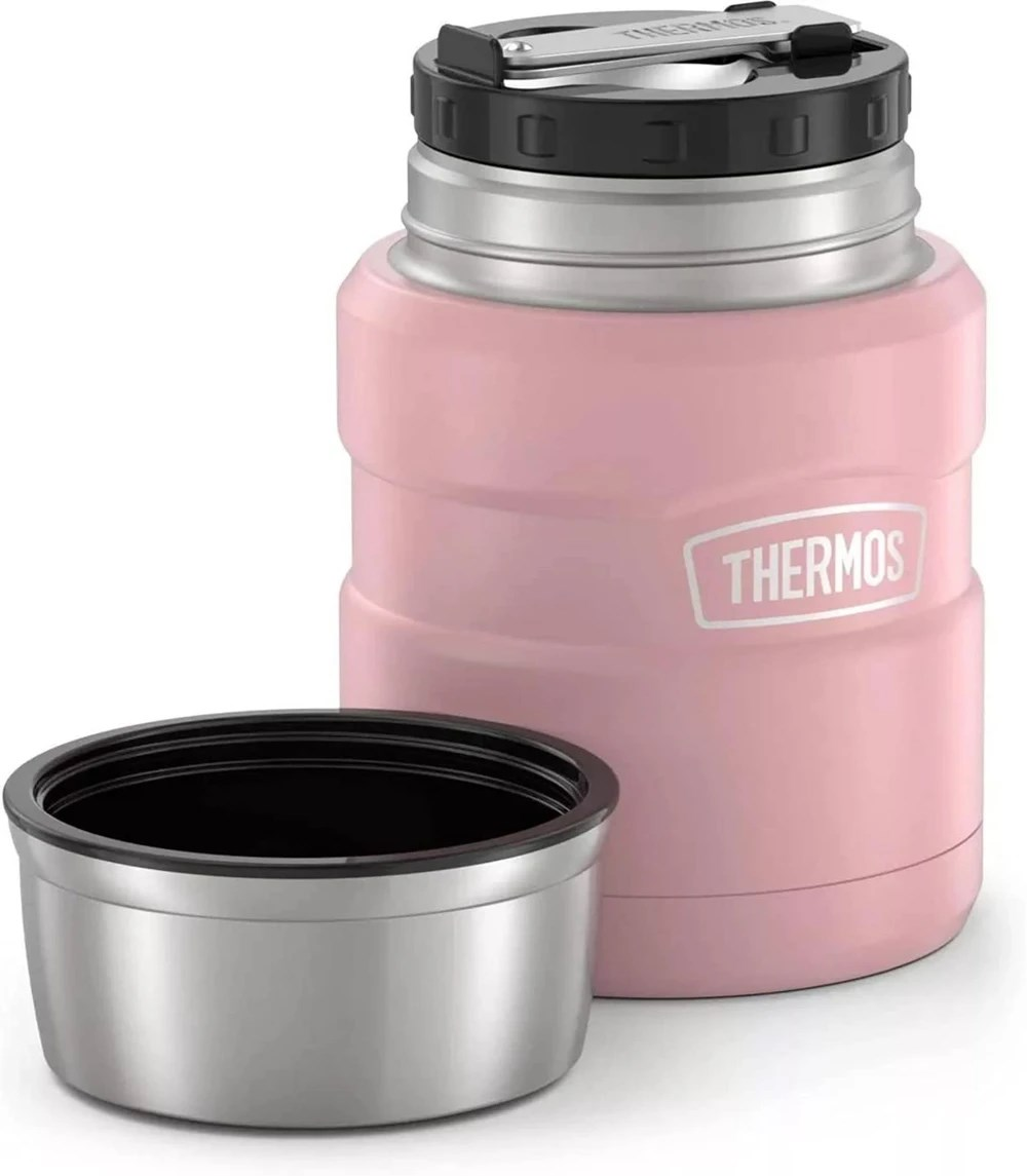 Gümüş kenarlı ve kapağı çıkarılmış pembe bir Thermos yemek kabı, beyaz arka planda.