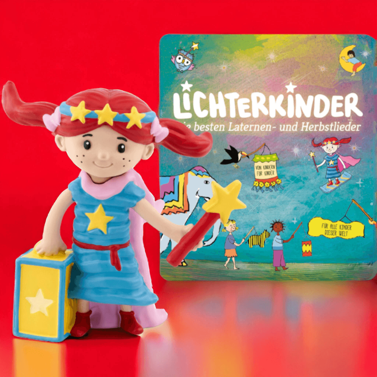 Eine Spielfigur in blauem Kleid hält einen Zauberstab vor einem bunt illustrierten Buch mit dem Titel Lichterkinder.