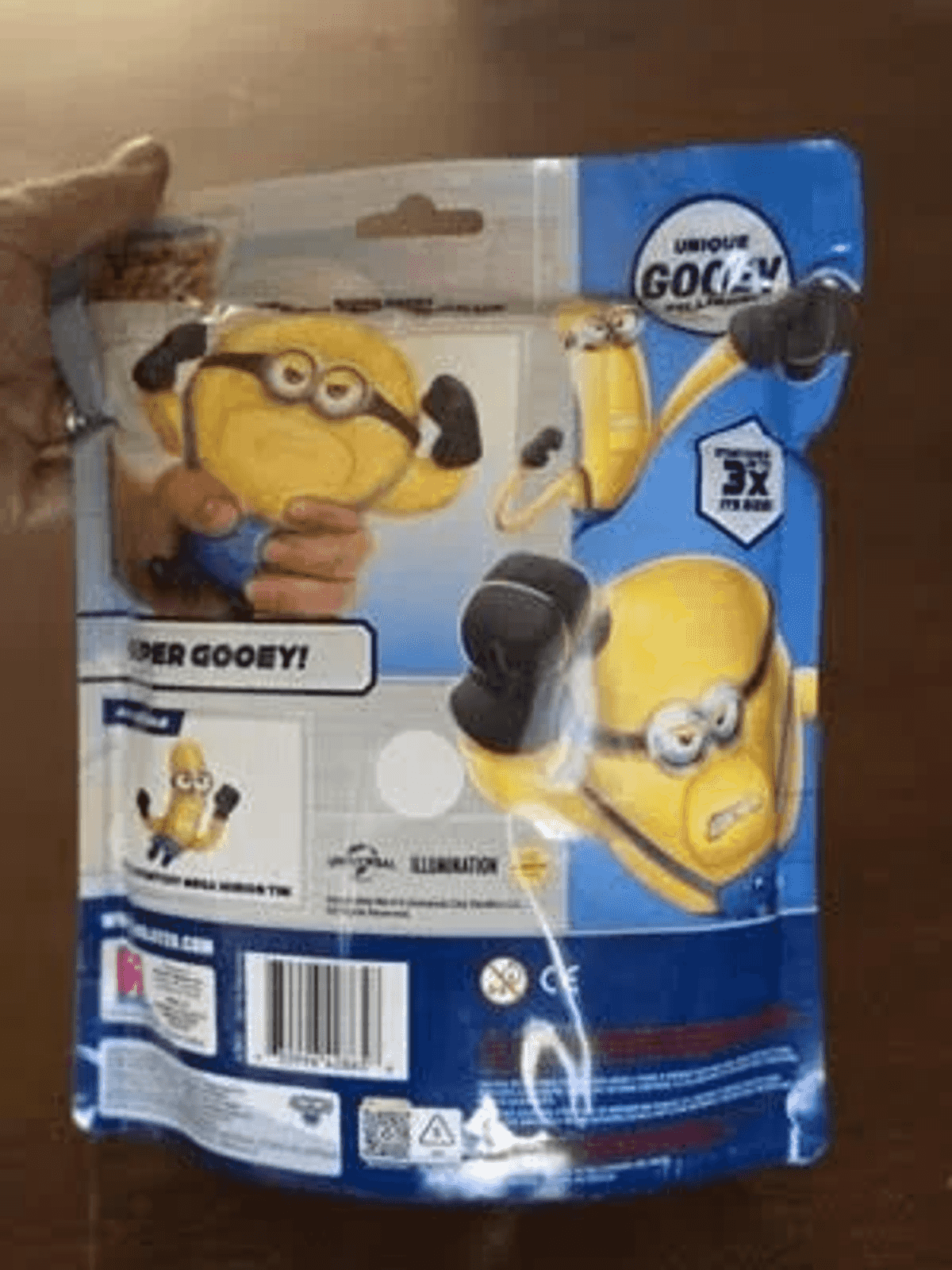 Blaue Minions-Spielzeugverpackung mit Bildern von gelben Figuren, Texten und Barcode auf der Rückseite.