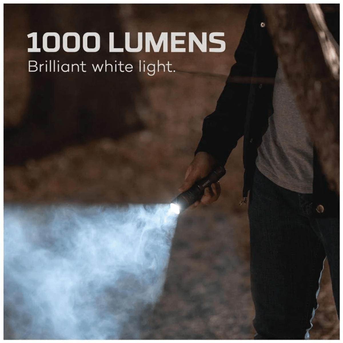 Personne tenant une lampe torche brillante dans une forêt, texte: 1000 lumens.