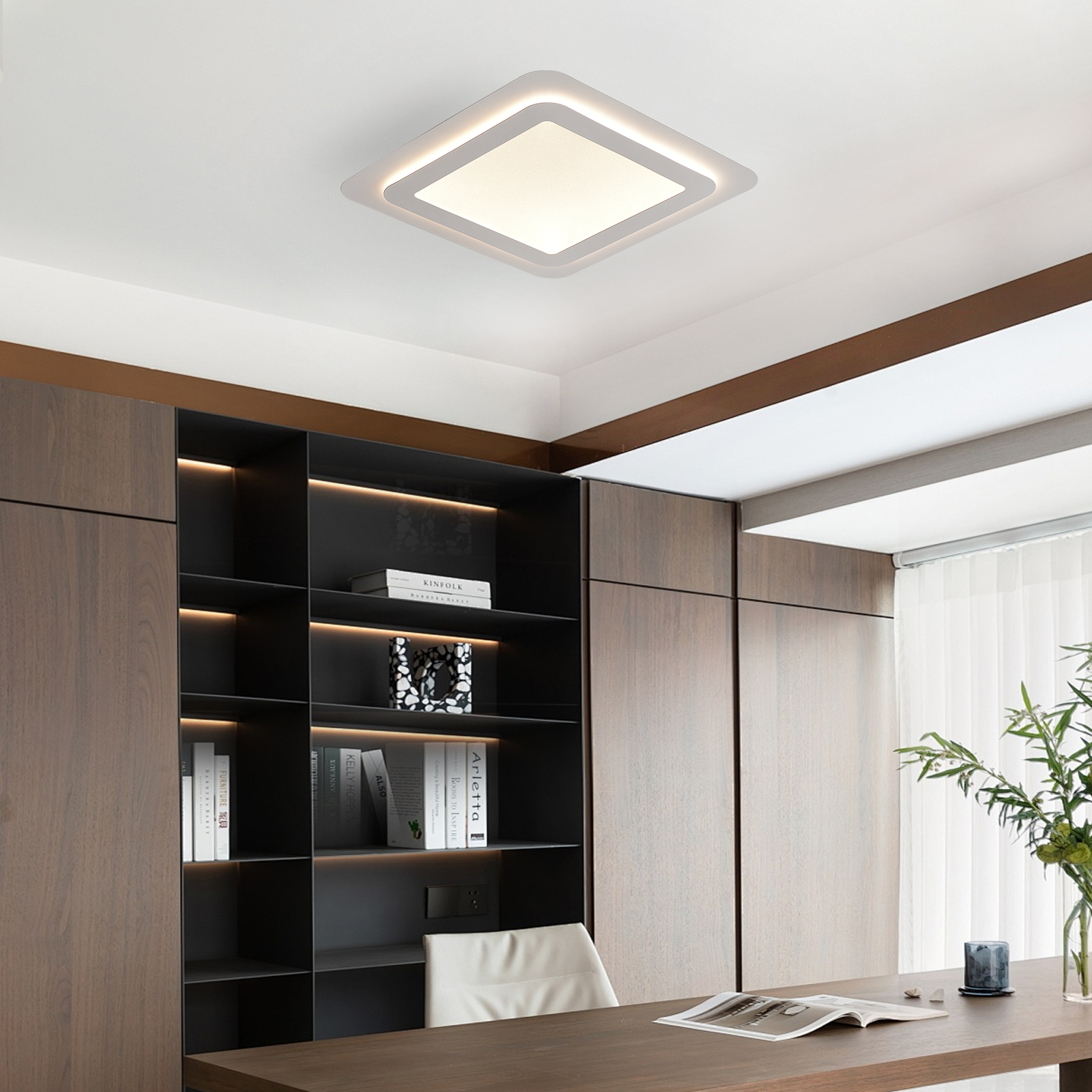 Eine moderne quadratische Deckenleuchte beleuchtet ein modernes Büro mit dunklen Holzregalen und einem Schreibtisch.