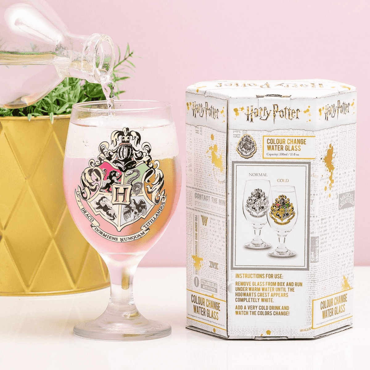 Wasser wird in ein Harry-Potter-Farbwechselglas gegossen, daneben steht die Verpackung.