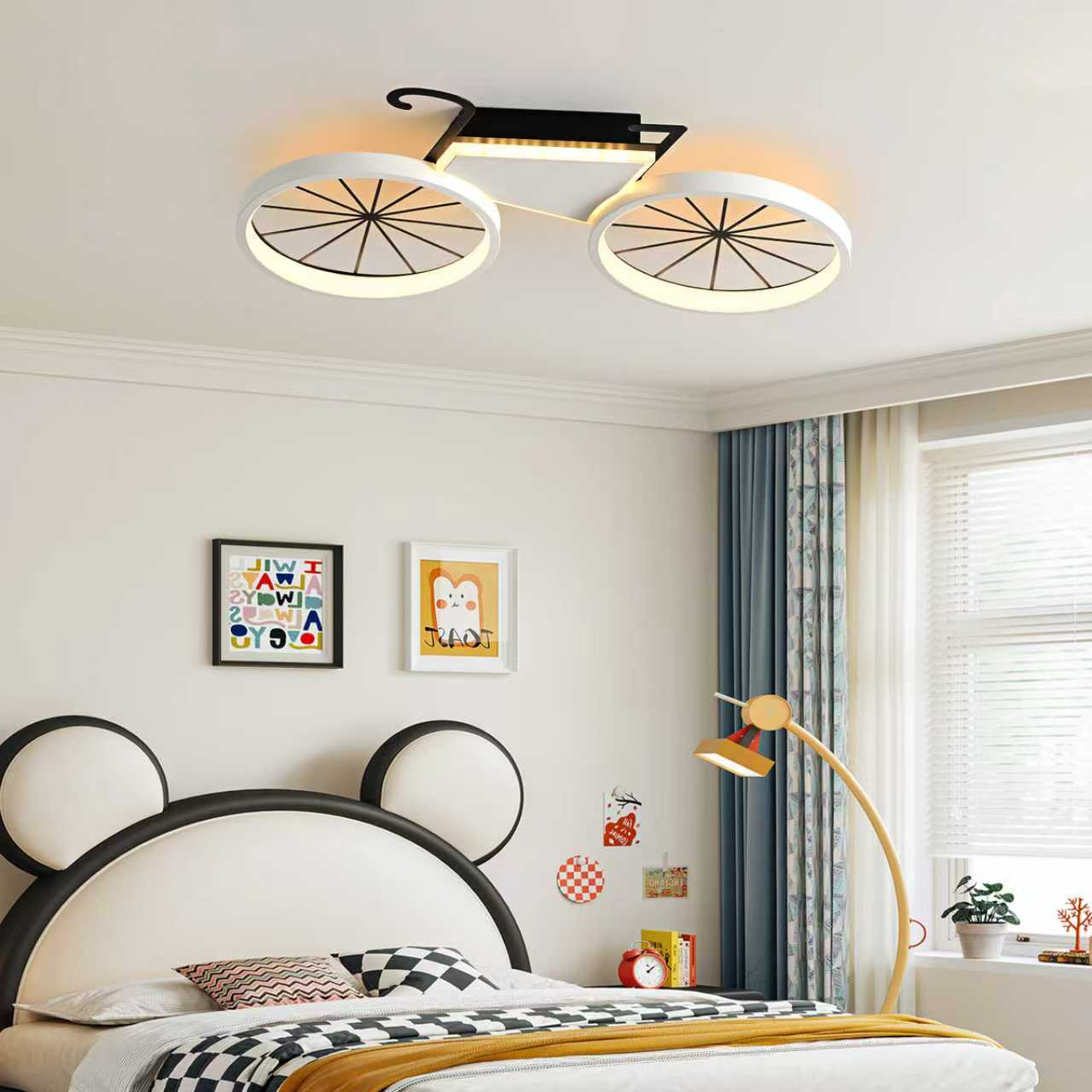 Kinderzimmer mit Fahrrad-Deckenleuchte, Micky-Maus-Bett, gelber Bogenlampe, bunten Bildern und weißem Vorhangfenster.