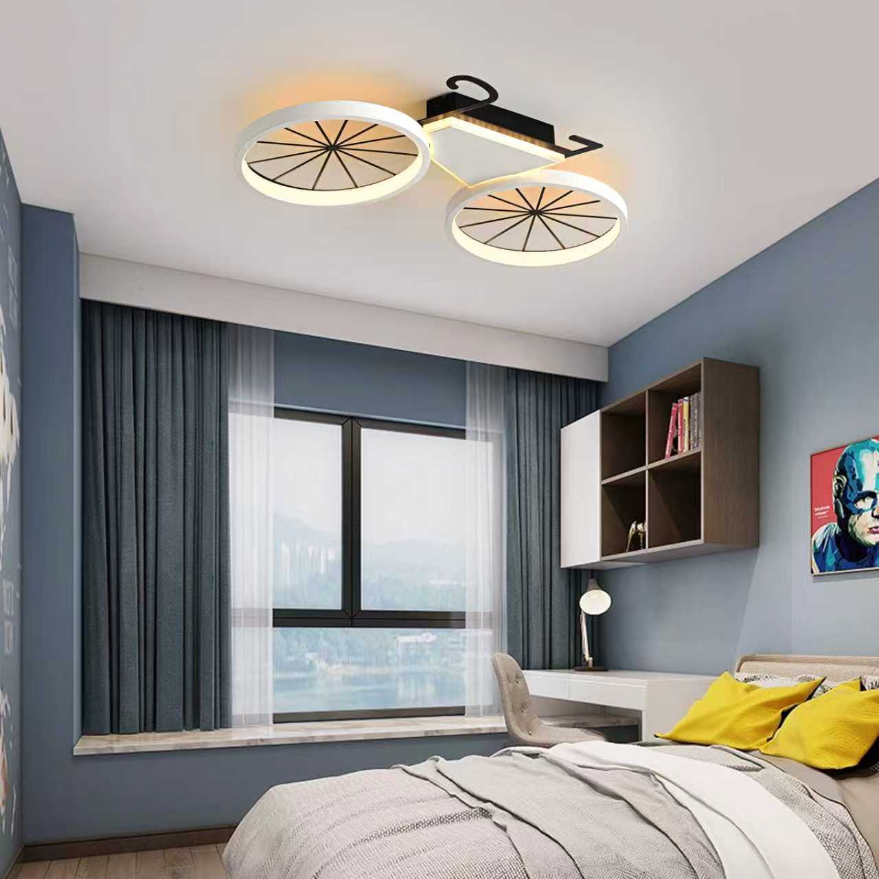 Ein Schlafzimmer hat blaue Wände, ein großes Fenster mit grauen Vorhängen und eine fahrradförmige Deckenlampe.