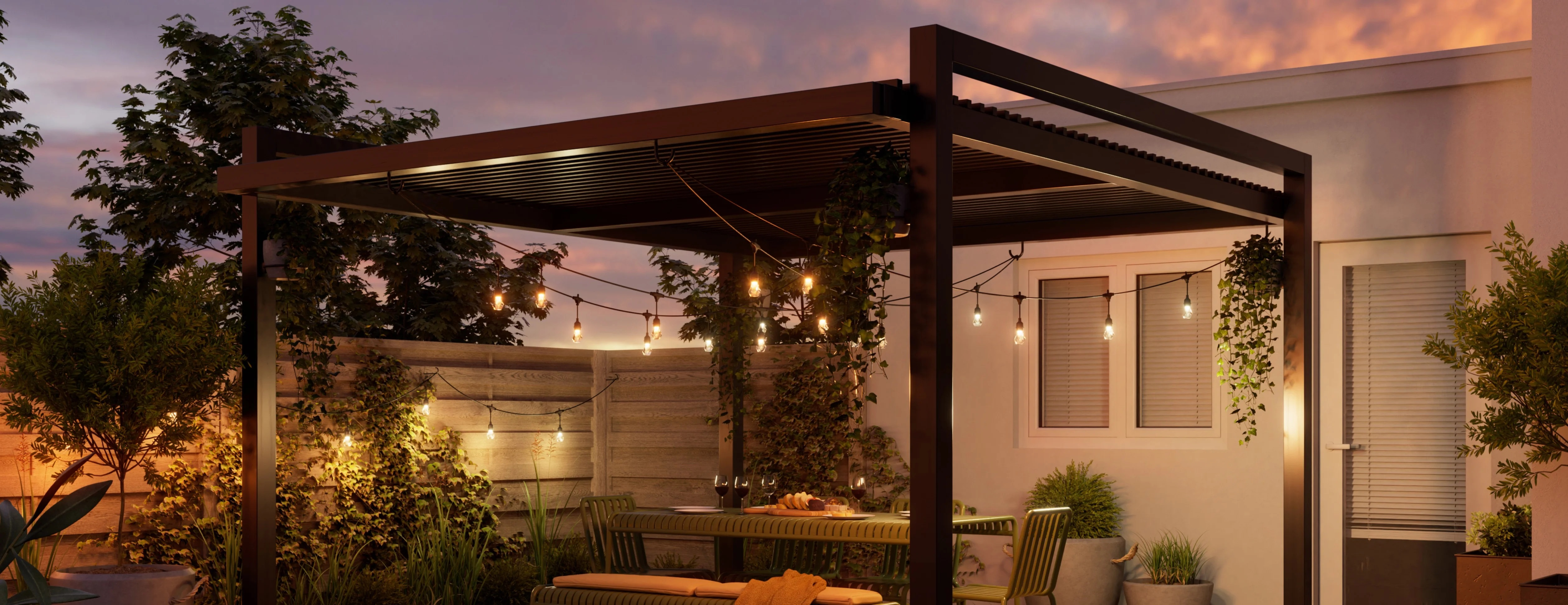 Moderna pergola nera da giardino con lucine, set da pranzo e piante al crepuscolo.