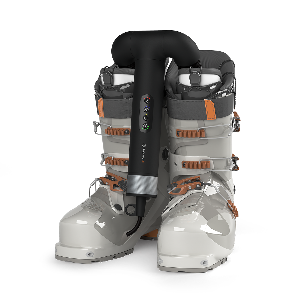Ein schwarzer Schuhtrockner zwischen grauen und orangen Skischuhen vor weißem Hintergrund.