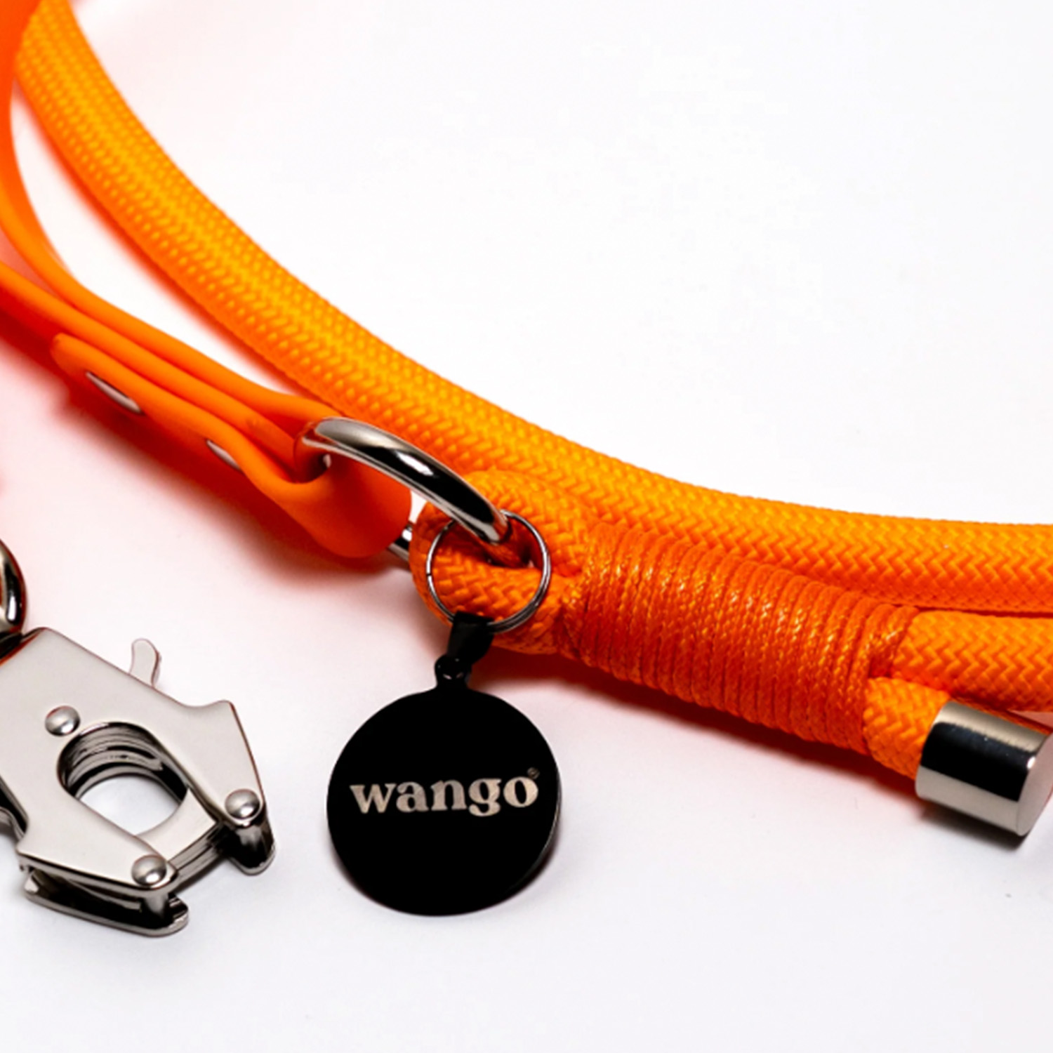 Una correa de perro de cuerda naranja con herrajes plateados y una etiqueta redonda negra etiquetada como wango.