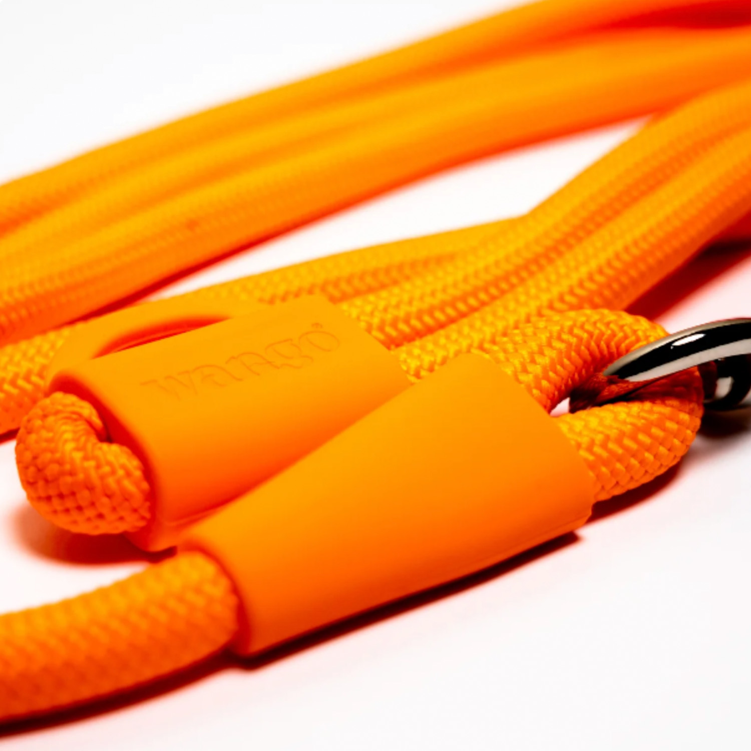 Correa de perro naranja brillante con marca de goma y anillo de metal sobre fondo blanco.