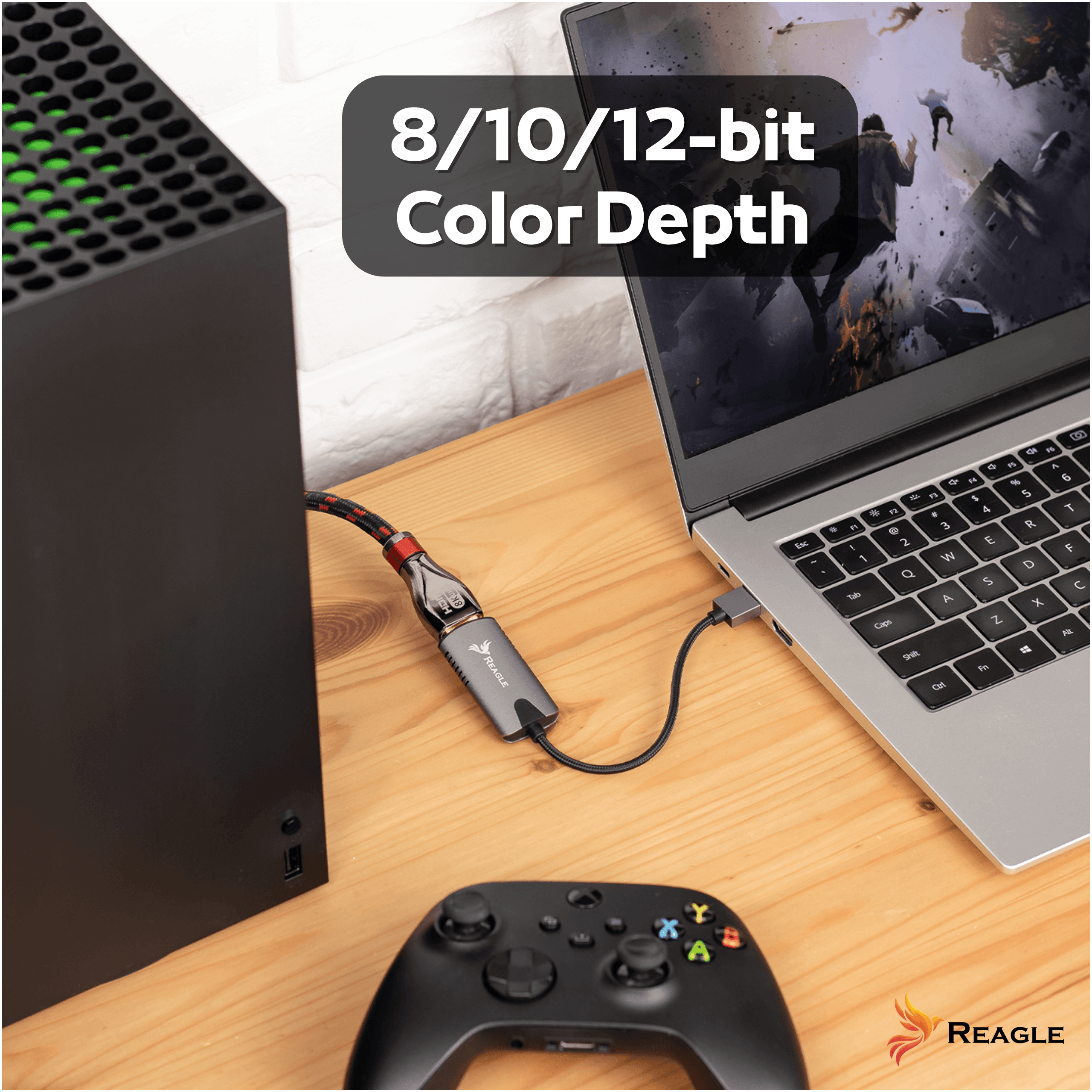 Una console e un laptop su una scrivania in legno, collegati da un cavo nero e un adattatore REAGLE.