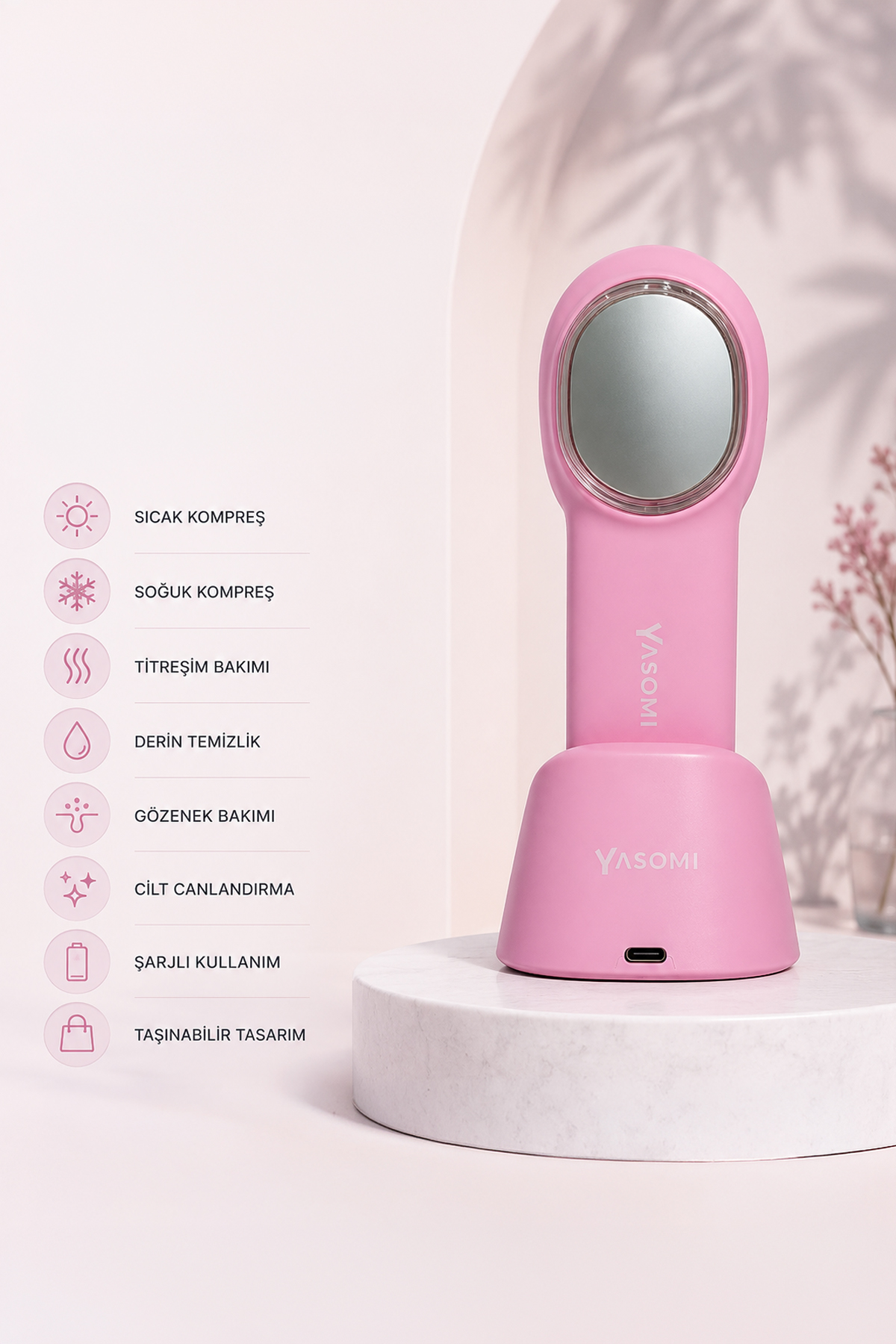 Pembe Yasomi cilt bakım cihazı beyaz mermer stantta, solda özellik ikonları.