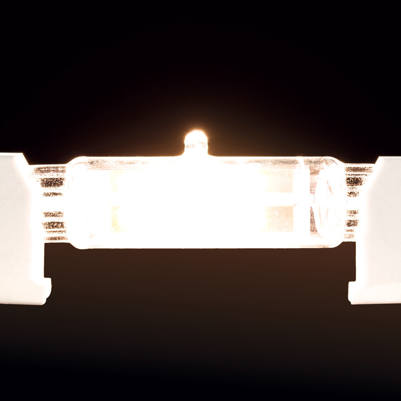 Eine helle Halogenlampe leuchtet intensiv vor dunklem Hintergrund.
