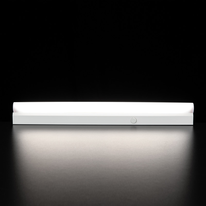 Eine weiße LED-Lichtleiste strahlt hell auf einer dunklen Oberfläche vor schwarzem Hintergrund.