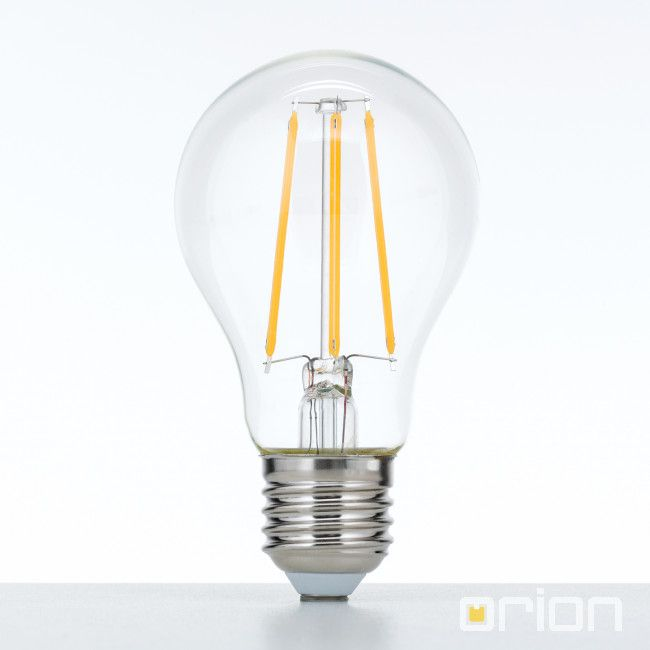 Eine klare LED-Glühlampe mit sichtbaren gelben Fäden auf einem weißen Untergrund.
