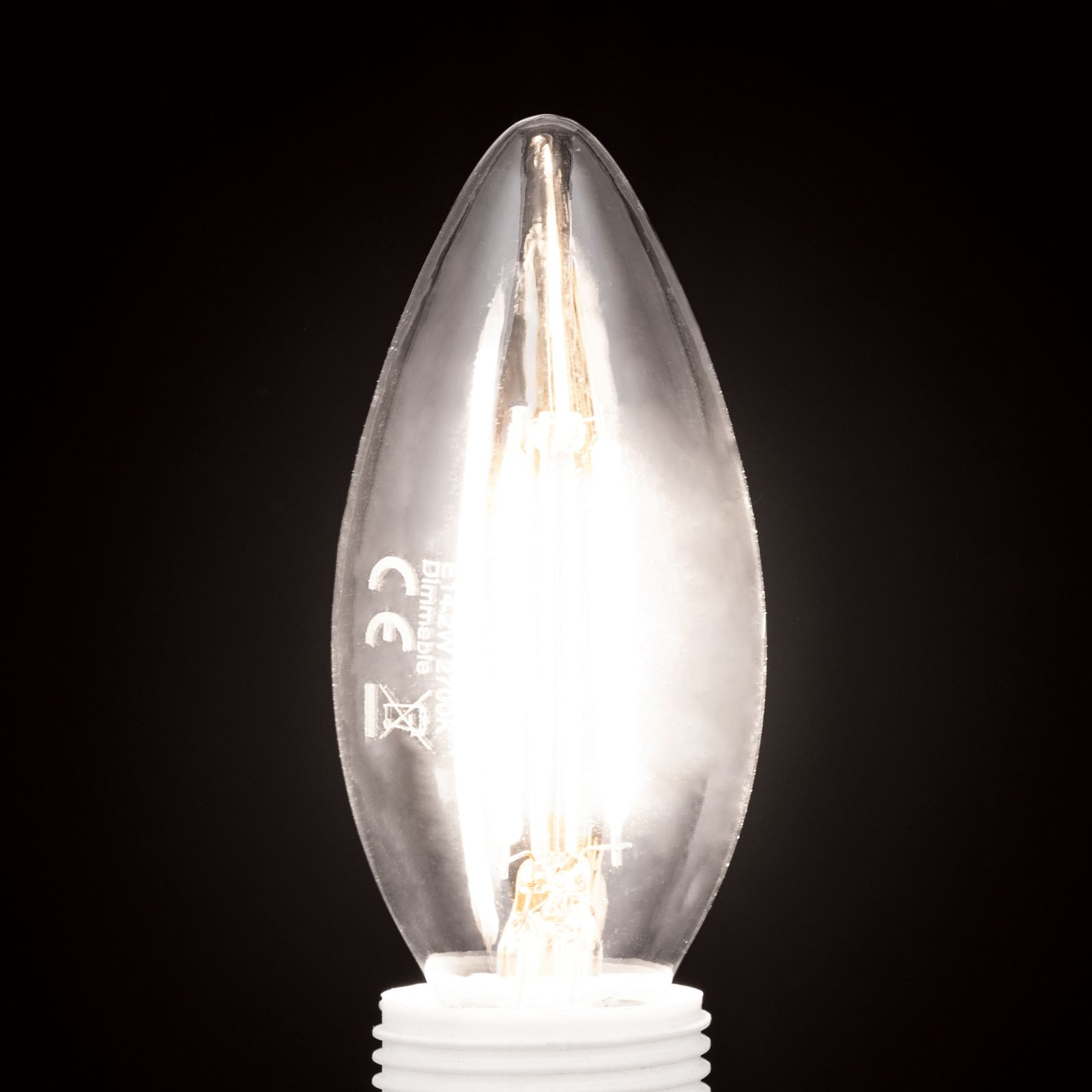 Eine brennende, kerzenförmige LED-Glühlampe mit weißem Sockel leuchtet hell vor einem schwarzen Hintergrund.