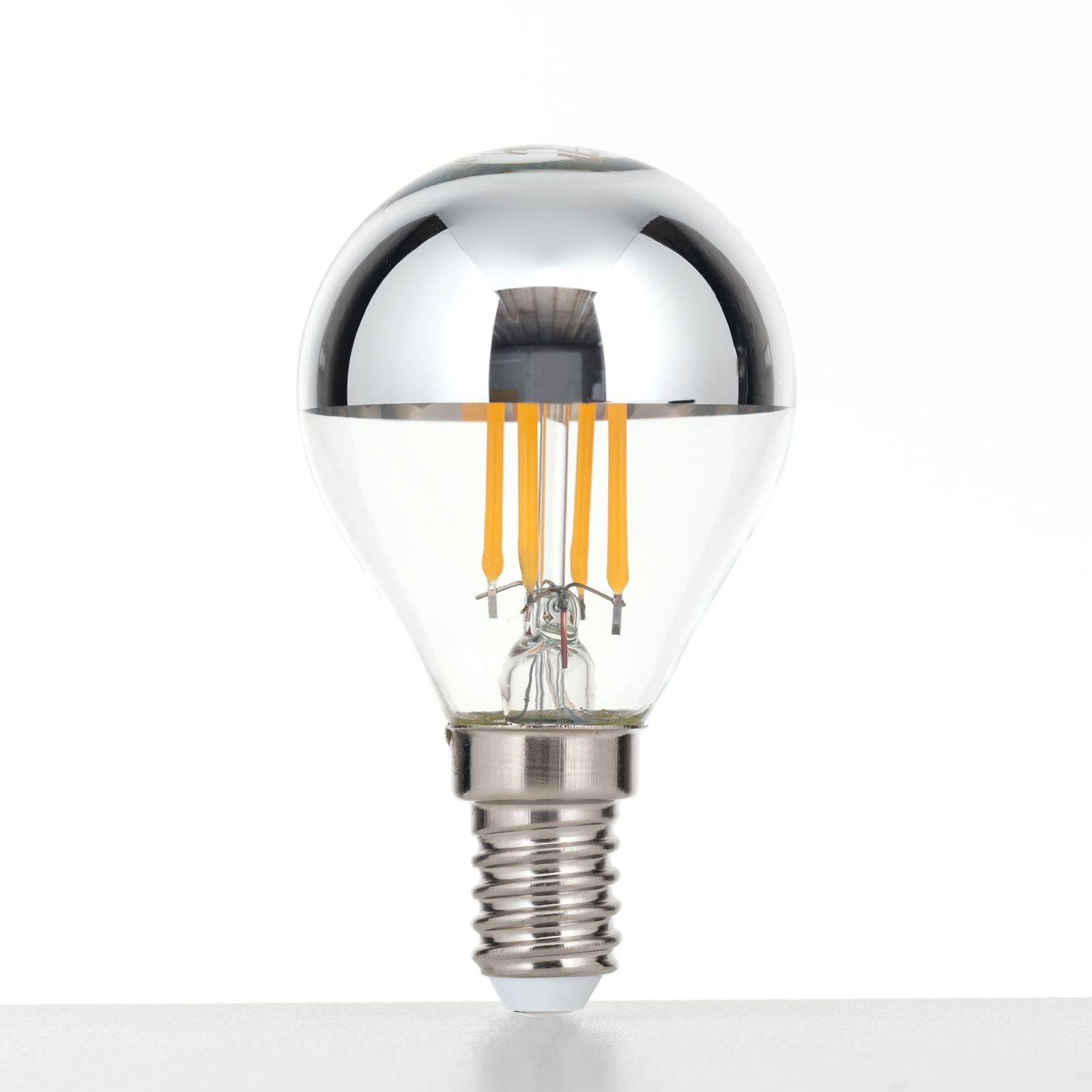 Eine LED-Glühbirne mit silberner Spiegelkappe, gelben Fäden und E14-Sockel vor weißem Hintergrund.