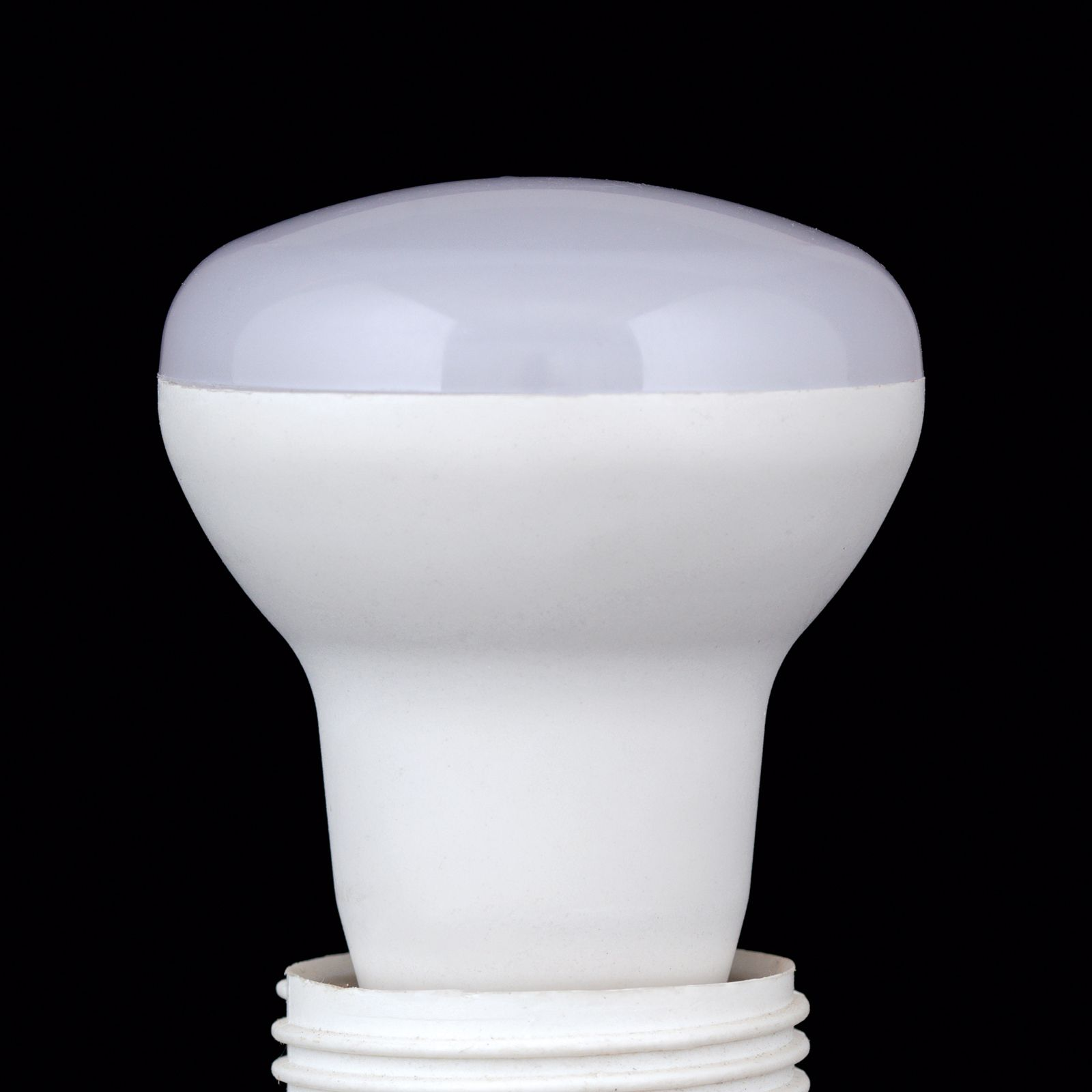 Eine weiße LED-Lampe mit mattierter Kuppel vor schwarzem Hintergrund.