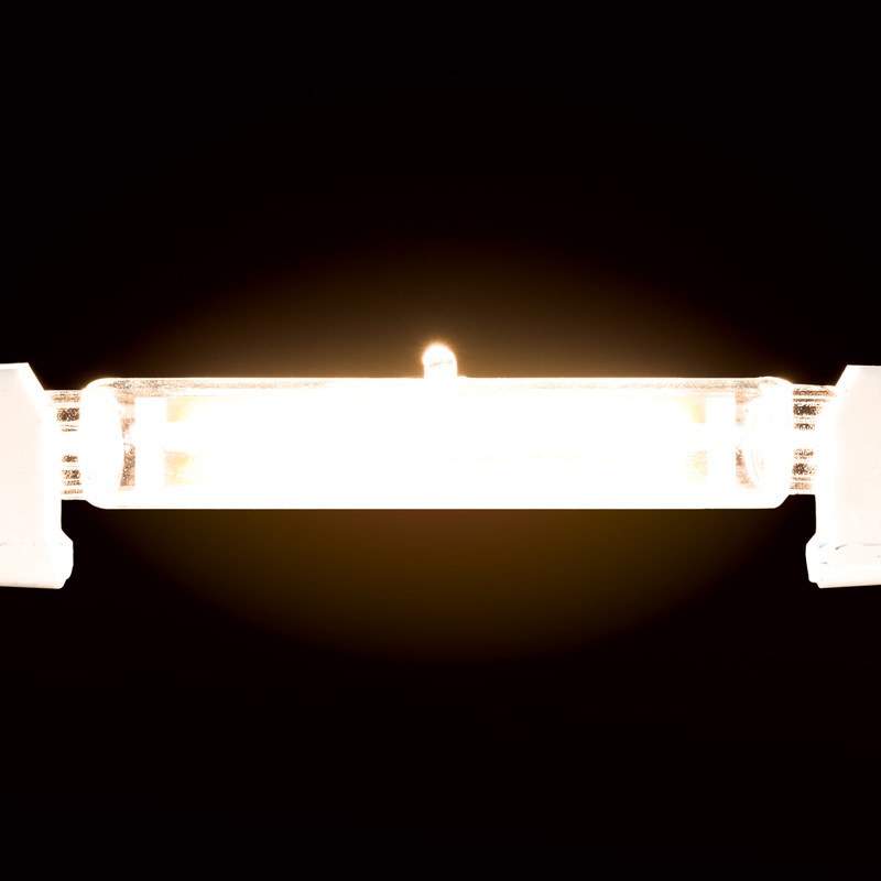 Eine eingeschaltete Halogen-Stablampe strahlt helles gelbes Licht in einem dunklen Raum aus.
