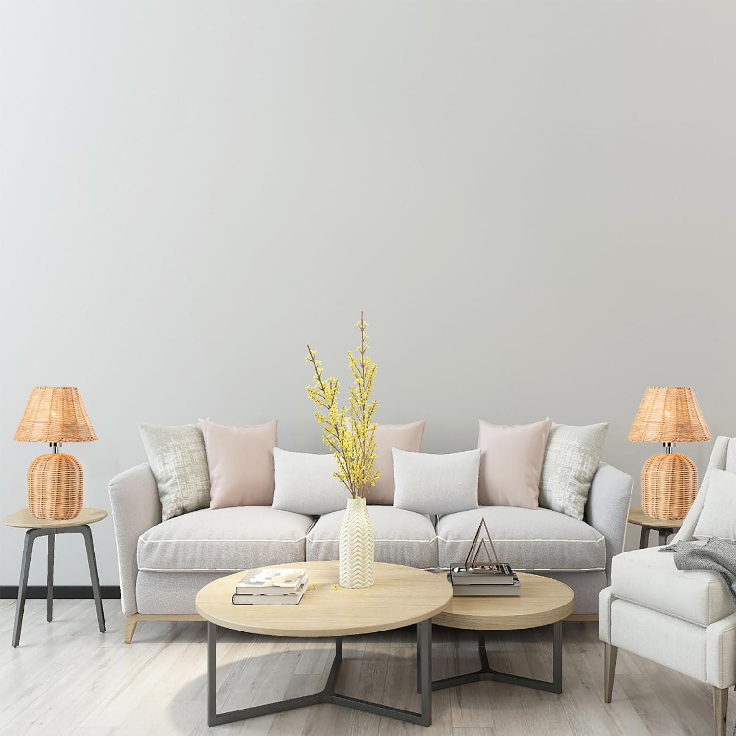 Ein helles Wohnzimmer mit grauem Sofa, Holztischchen und Korblampen vor einer weissen Wand.