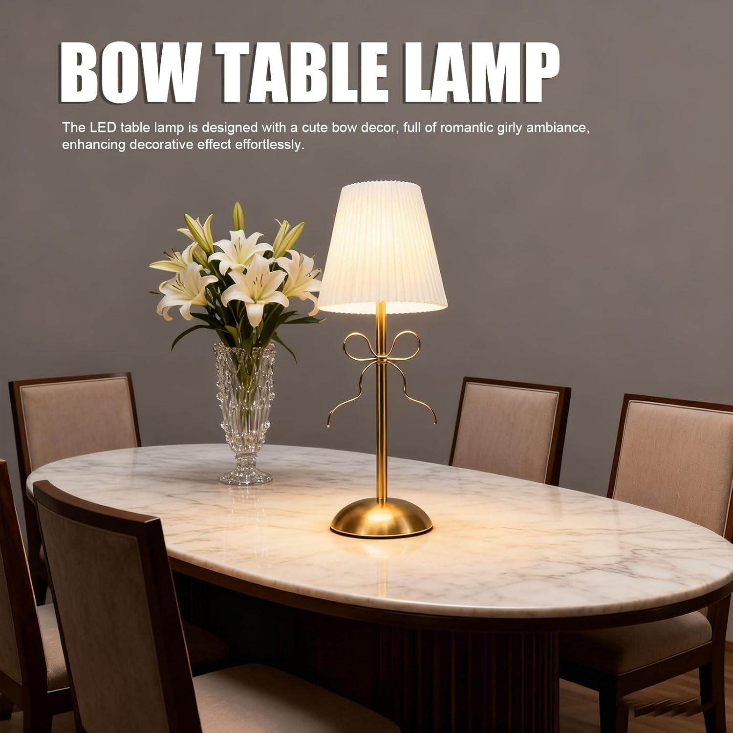 Eine goldene Schleifen-Tischlampe und weiße Lilien in einer Kristallvase auf einem Marmortisch.