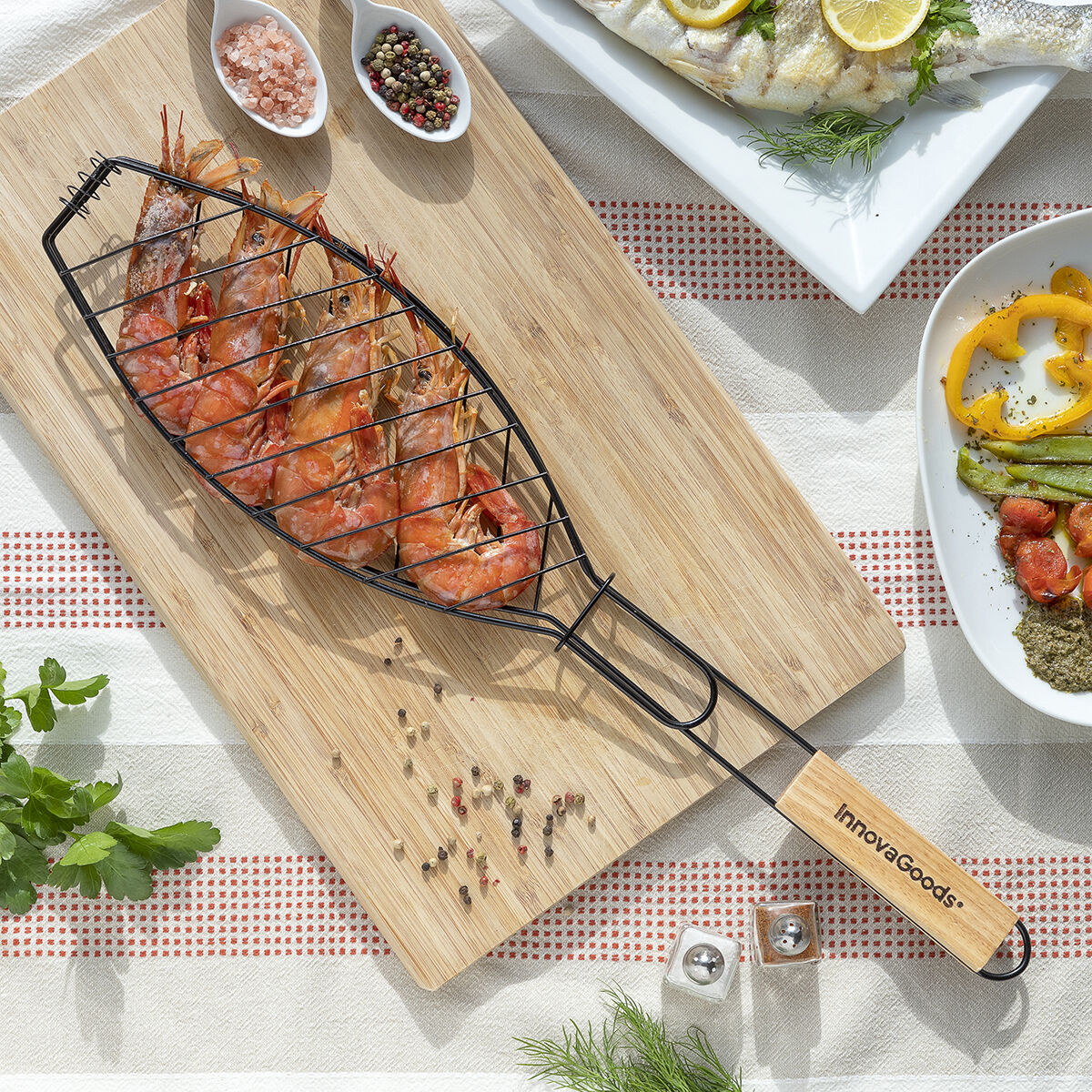 Gegrillte Garnelen in einem Metallkorb auf einem Holzbrett, umgeben von Gewürzen und Gerichten.