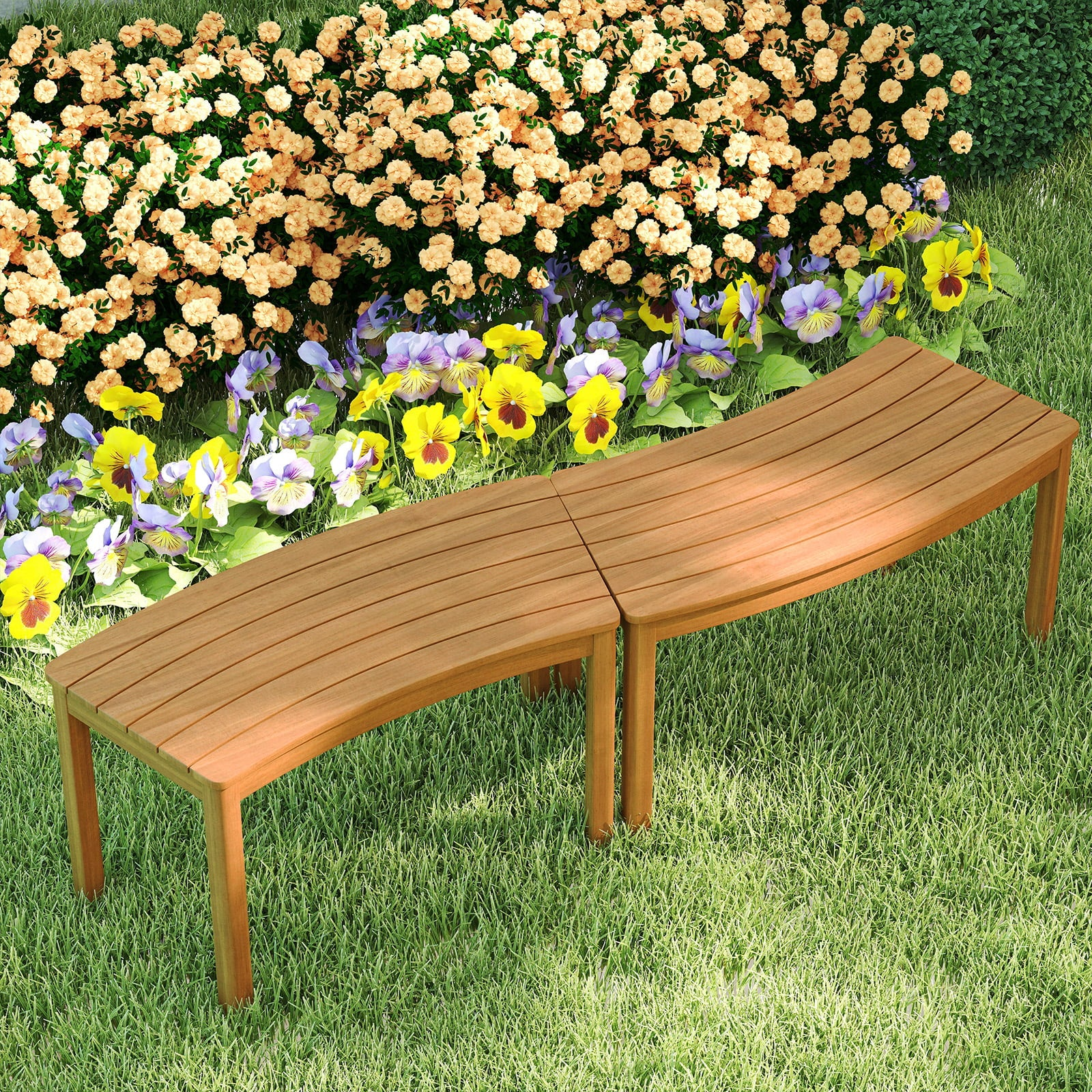Een gebogen houten bank staat op groen gras voor een tuinbed met gele en paarse bloemen en perzikstruiken.