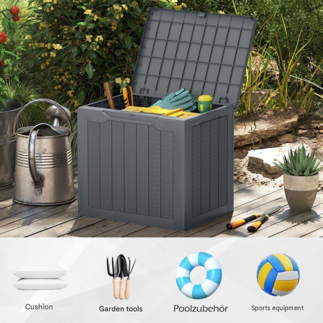 A grey plastic outdoor storage box with an open lid stands on a wooden deck, surrounded by plants and garden tools.