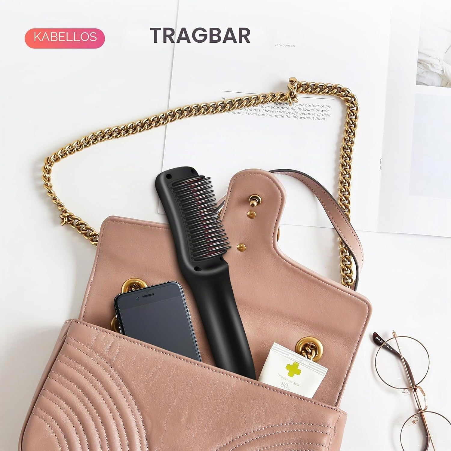Rosa Handtasche mit Kette enthält ein schwarzes Haarstyling-Gerät, Smartphone und eine Tube.