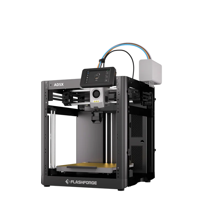 Ein schwarzer Flashforge AD5X 3D-Drucker mit goldenem Druckbett und weißer Filamentbox vor dunklem Hintergrund.