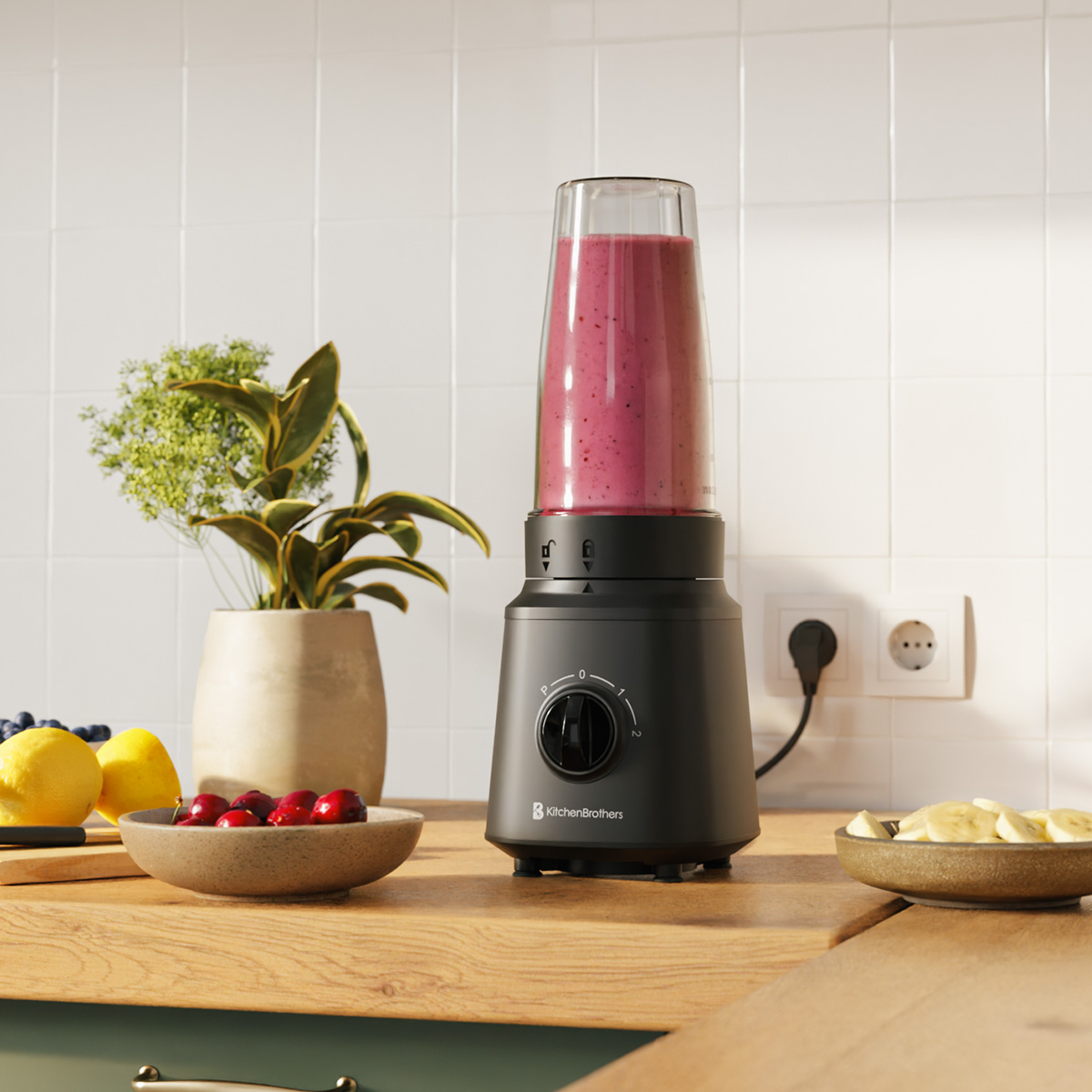 Ein schwarzer Standmixer mit rotem Smoothie, frischen Früchten und einer Topfpflanze auf einer Holzarbeitsplatte.