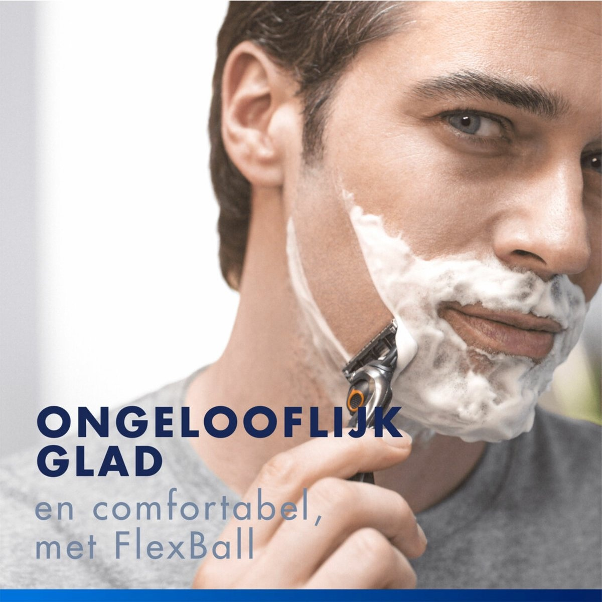 Un uomo si sbarba il viso usando schiuma da barba e un rasoio.