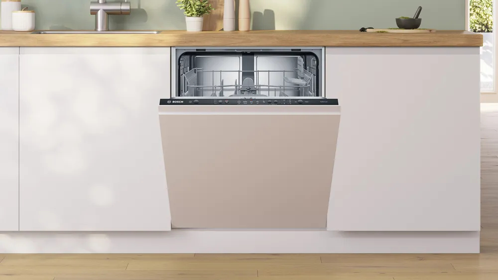 Una lavastoviglie Bosch a incasso è installata leggermente aperta in una cucina moderna con piano in legno.