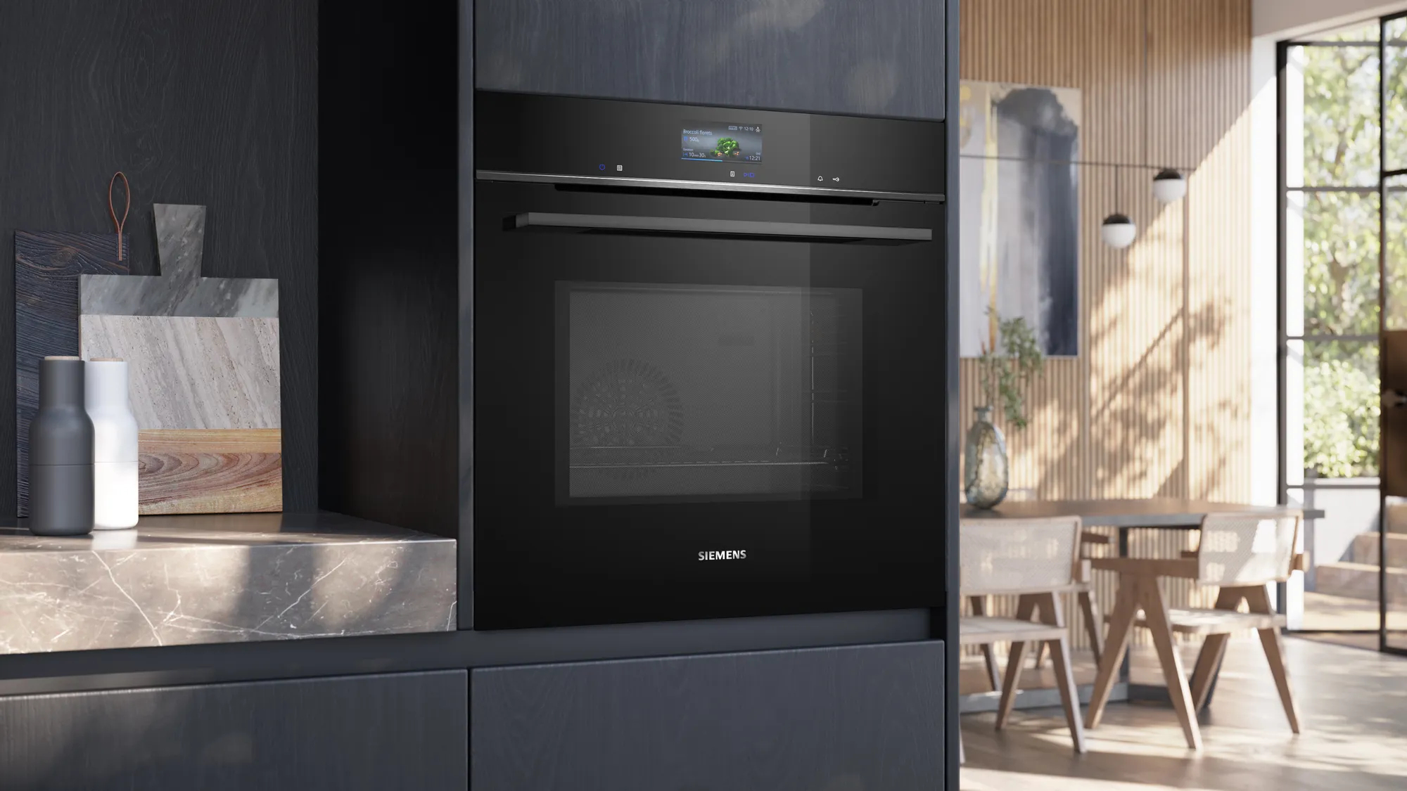 Moderno forno da incasso Siemens nero in una cucina luminosa con tavolo da pranzo in legno e sedie sullo sfondo.