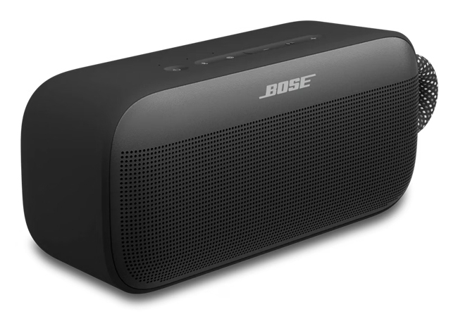 Un altavoz Bluetooth portátil Bose negro sobre fondo blanco, con rejilla de malla, controles en la parte superior y una correa.