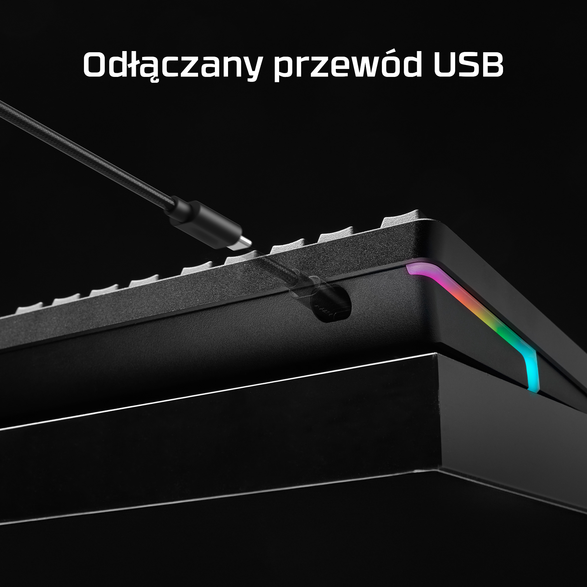 Un cable USB desmontable se conecta a un teclado negro con iluminación RGB.