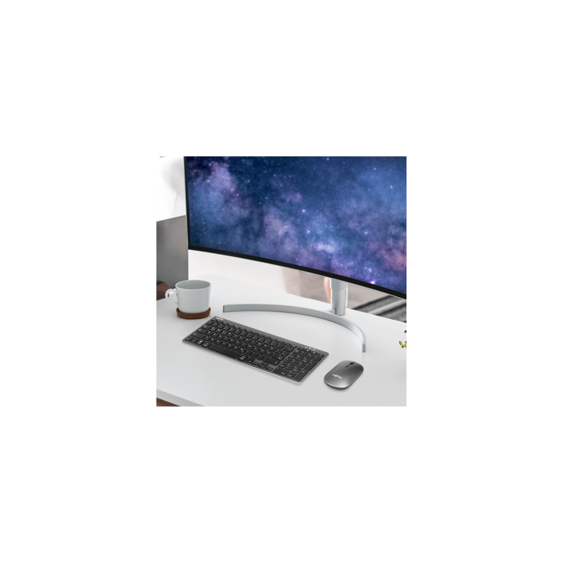 Una scrivania con monitor curvo, tastiera, mouse e tazza da caffè bianca.
