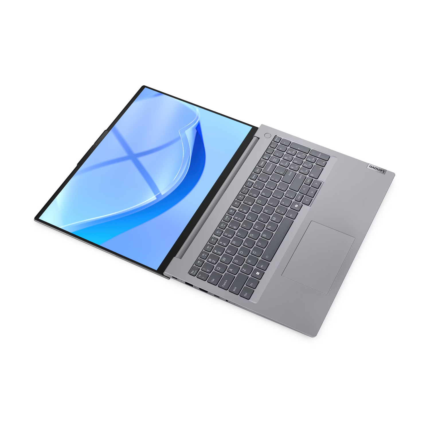 Beyaz arka planda açık duran gümüş renkli bir Lenovo dizüstü bilgisayar, ekranda mavi soyut desen var.