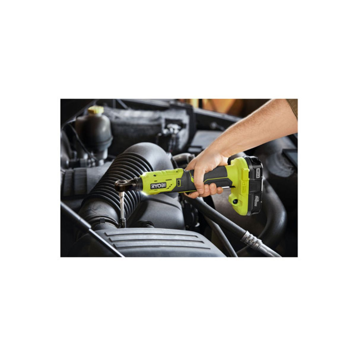 Eine Person benutzt eine hellgrüne Ryobi Akku-Ratsche an einem Auto-Motor.
